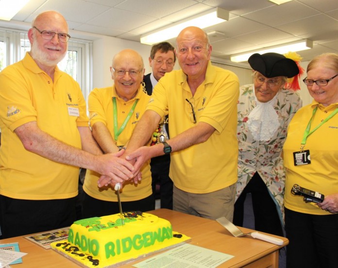 Photo of CUTTING the cake are Andy Worth, Peter Foster and Andy Venton watched by Mayor Tim Harries, Town Crier Alistair Chisholm and fellow broadcaster Heather Foster